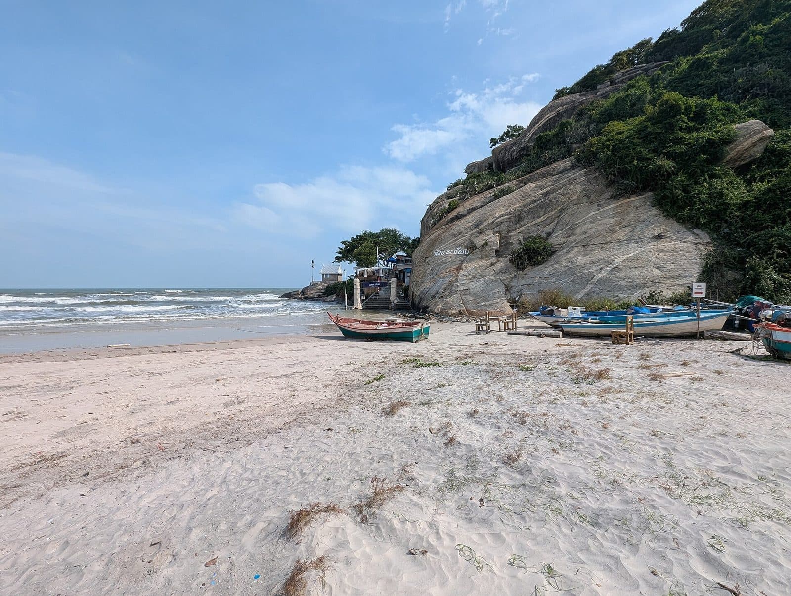 Fishing boats on the sand below a rocky headland, Hua Hin