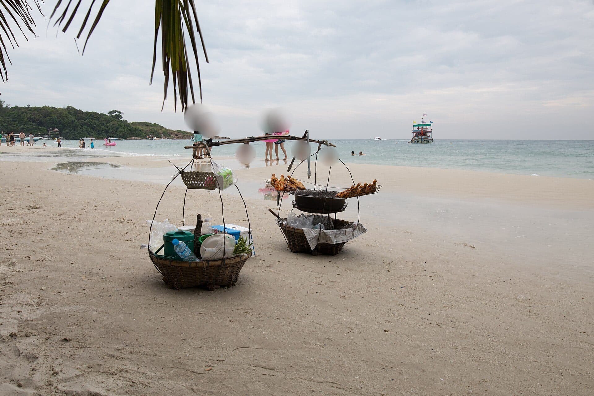 A vendor's baskets of grilled snacks on a Koh Samet beach